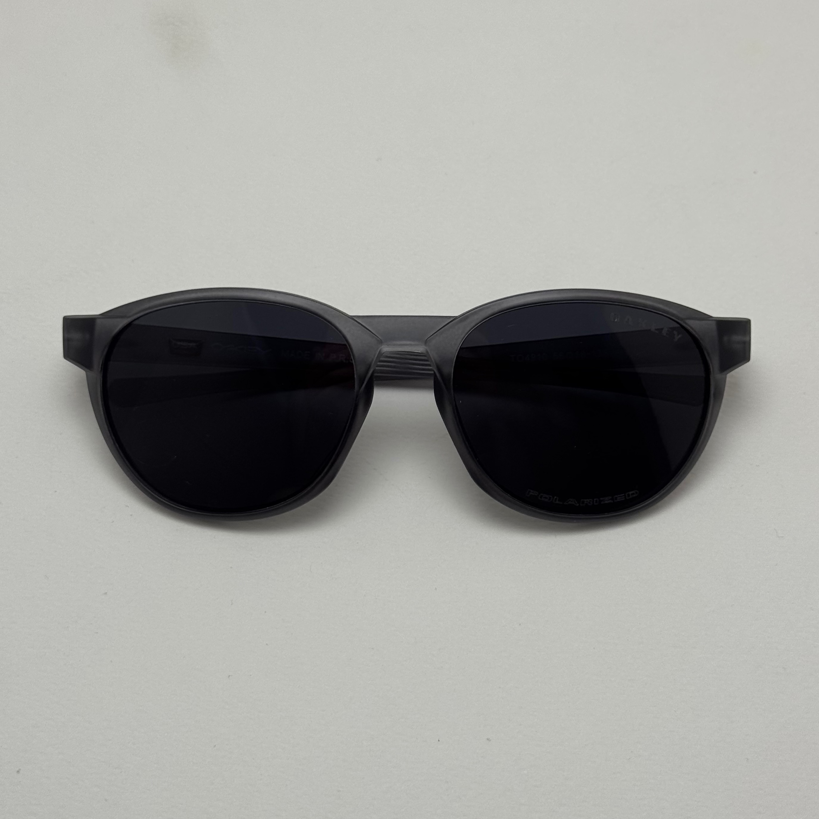 عینک آفتابی پلاریزه اوکلی Oakley طوسی عدسی مشکی گرد کد TO4910