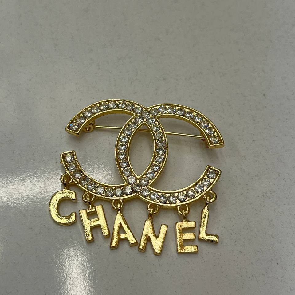 گل سینه نگین جواهری مدل شنل Chanel طلایی تنوع طرح رنگ کاملا ثابت کد bn (پس کرایه)
