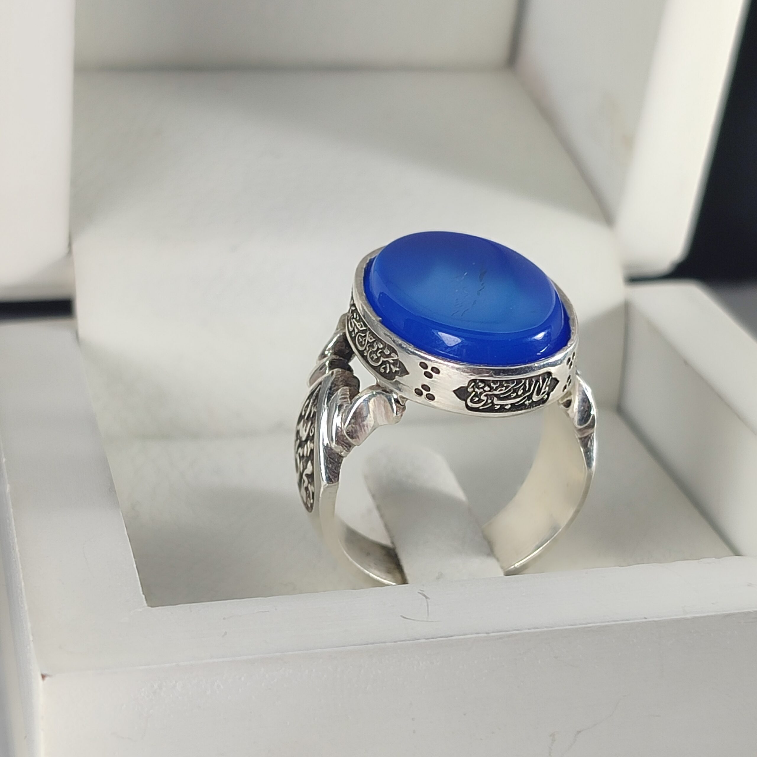 انگشتر نقره باسنگ عقیق آبی ذکر روی رکاب (ذکر ولایت امیر المومنین) ذکر بغل رکاب (محمدنبی الله) و (علی ولی الله) کد 2343